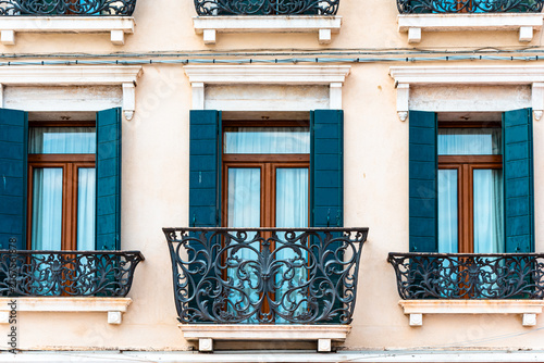 Obraz na plátne Elegant European building facade with ornate wrought iron balconies and shutters