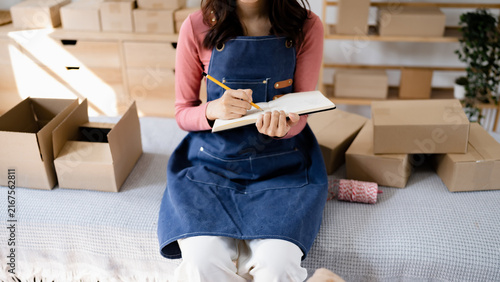 Quadro su tela Small business owner packing in the cardbox preparing parcel for delivery online