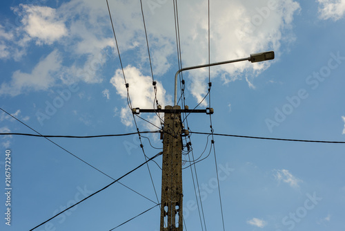Utility pole with overhead power lines against a blue sky