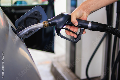 Canvastavla Person refueling a vehicle with a gas pump at an outdoor petrol station, represe