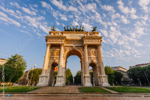 Arco della Pace monument in Milan, Italy, featuring classical architecture and sculptures against a blue sky with scattered clouds