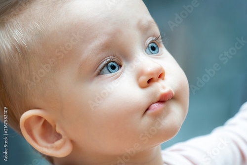 Obraz na plátně Curious baby with bright blue eyes looking up