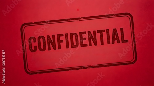 Confidential rubber stamp imprint in dark ink on a textured red paper background with secret document classified info official stamp restricted access security mark ink impression stamp text