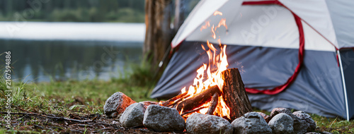 Camping tent by serene mountain lake with campfire, AI generated