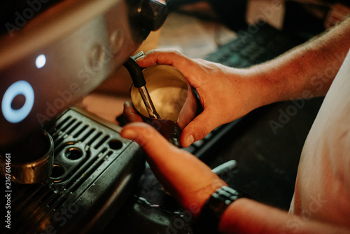 Foto Close-up of a barista using a portafilter and espresso machine to prepare fresh coffee, showcasing professional brewing technique in a cafe