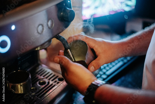Quadro su tela Close-up of hands preparing espresso with a professional coffee machine, highlighting barista technique, coffee preparation and specialty cafe culture