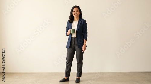 Smiling Asian Businesswoman in Suit Holding Coffee Cup Against White Background