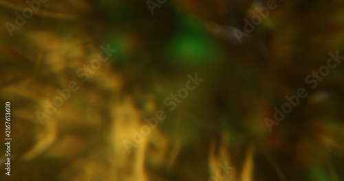 Blur bright glare. Glimmer art. Yellow orange green colorful lens flare shiny gleam kaleidoscope on light abstract bokeh background.