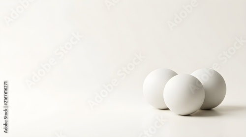 Three white eggs stacked on minimalist white background for clean product photography