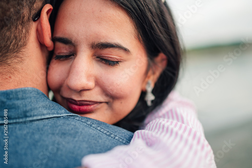 Foto Happy young woman smiling with closed eyes, embracing and feeling tender affecti