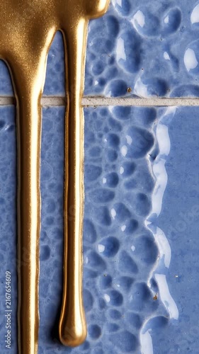 Gold Metallic Paint Drips Over Textured Blue Ceramic Tiles Abstract Surface Design