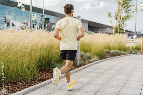 Фотография Morning jogger enjoys the fresh air and beautiful scenery in a modern urban park
