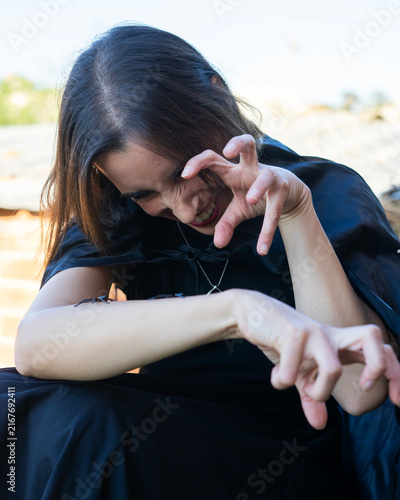 Woman Posing with Spiders on Arm in Moody Outdoor Setting