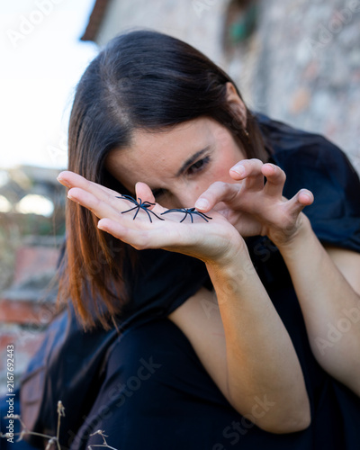 Woman Holding Toy Spiders Outdoors