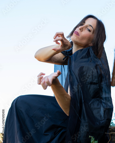 Woman in Black Cape Posing Dramatically Outdoors