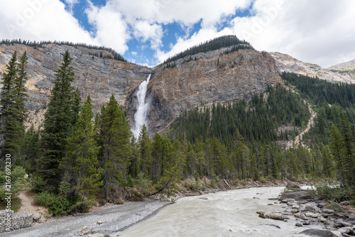 Takakkaw Falls in Yoho National Park, Canada, cascading down a dramatic Rocky Mountain cliff above dense evergreen forest on a scenic summer day.