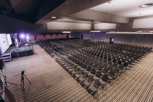 Obraz na plátně Empty Conference Hall: Rows of empty seats fill a grand conference hall, ready to welcome an audience for a presentation or event, highlighting anticipation and potential