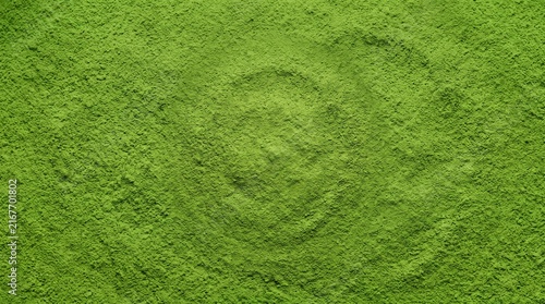 Vibrant green matcha powder texture with a subtle circular indentation in the center