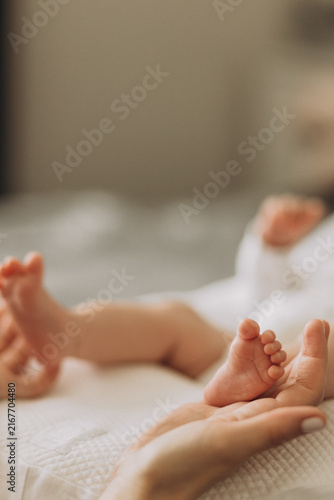 Принти на полотні Newborn's Tiny Feet: Delicate baby feet, held gently in an adult's hand, symbolize new beginnings and the preciousness of new life