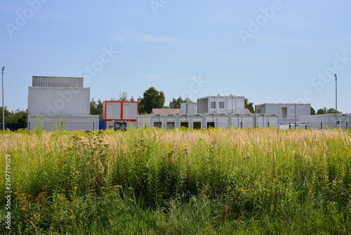 Construction site with modular cabins and office containers in a summer field