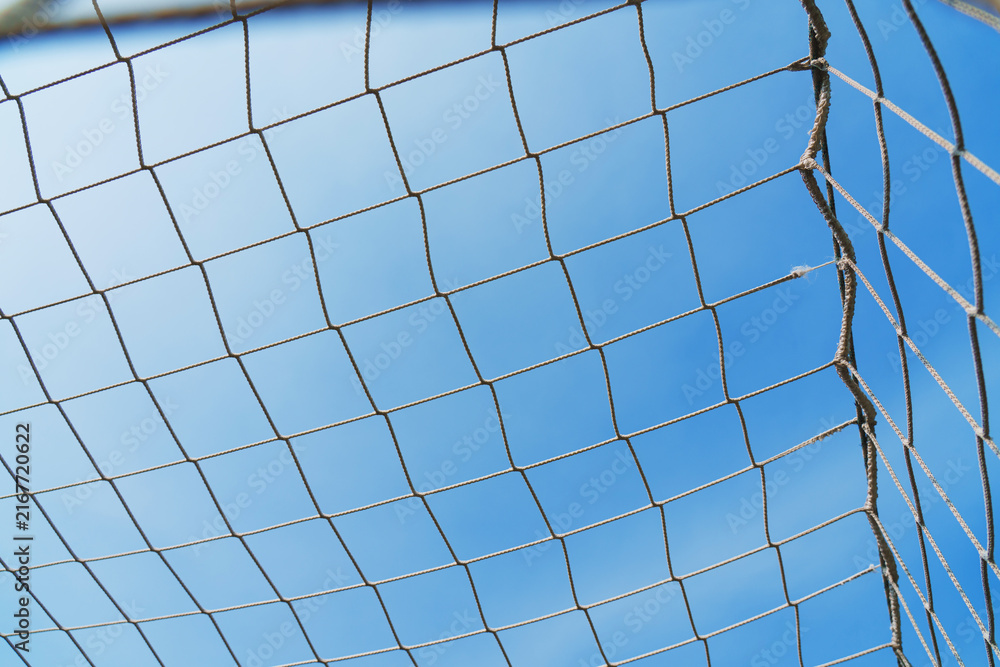 Fototapeta premium Close-up textured soccer net on soccer goal isolated on free sky background.