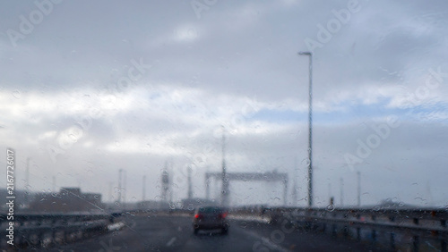 The view from the car onto the road in the heavy rain. Blurred background.