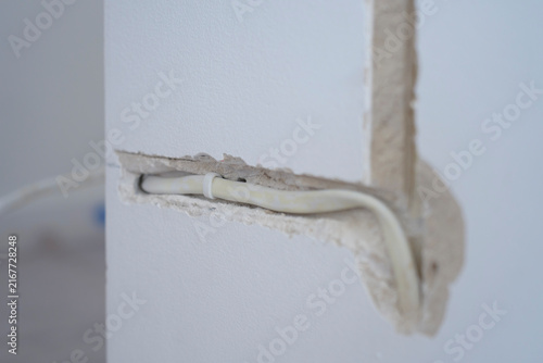Electrical cable placed inside channel cut into interior wall. Cable installation and home wiring
