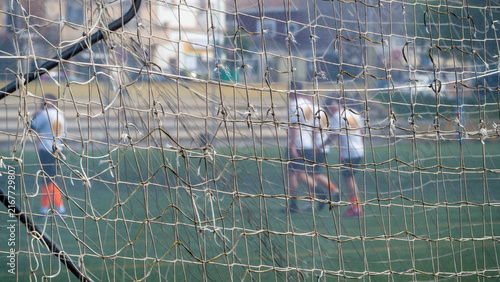 A net on a football field where people are playing football. Blurred background.