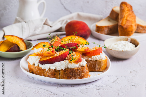 Cuadro en lienzo Peaches, ricotta and thyme on ciabatta on a plate on a table
