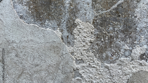 Cuadro en lienzo Close‑up of a weathered wall with layers of deteriorating plaster and exposed rough substrate, creating an abstract architectural texture with contrasting surfaces, erosion, and aged character