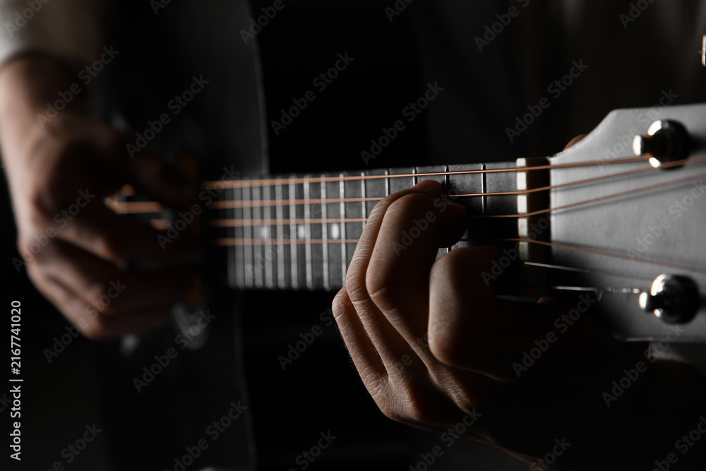 Fototapeta premium Music education and creative expression, hands playing acoustic guitar strings in a dark, moody setting