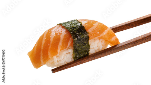 Fotografie Salmon nigiri sushi with nori seaweed held by wooden chopsticks, isolated on tra