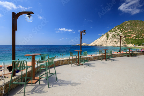 Bar chairs and tables on the terrace at the famous Petani Beach on the Greek island of Kefalonia.