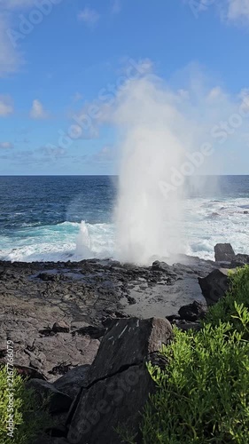 Blowhole spouting large plumes of water on Galapagos Islands with churning ocean waves vertical video