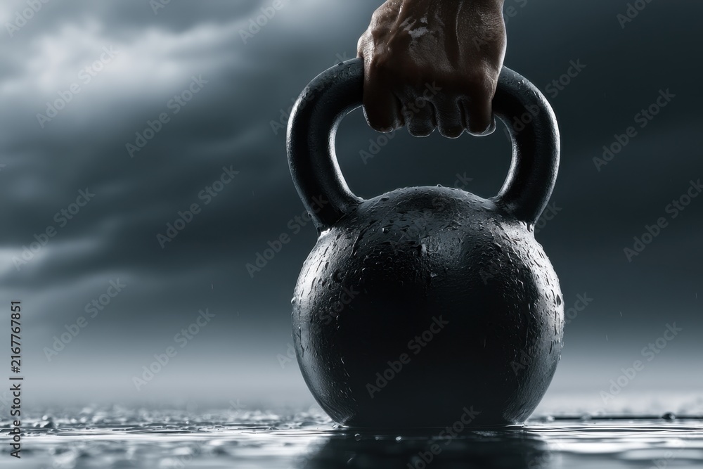 Obraz premium Strong hand gripping a wet kettlebell on reflective surface with dark stormy sky background symbolizing determination and strength training