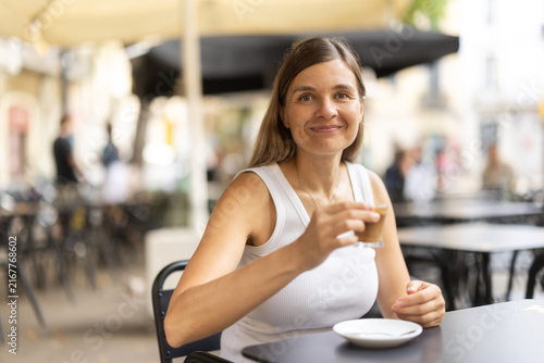 Фотография Woman drink coffee in street cafe