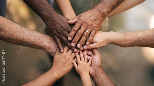 Hands of people of various ages and skin tones naturally coming together at the center of the composition—a gesture of unity and support.