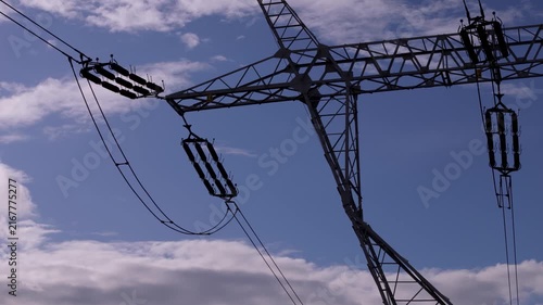 Silhouette of high voltage power transmission pylon against dramatic blue sky in smart energy grid network