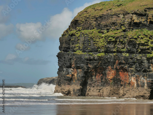 Foto Wide sandy beach meets ocean waves under clear sky