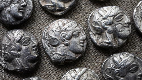 Fotografie Close-up of coins of ancient Athens with profile faces on rustic textile