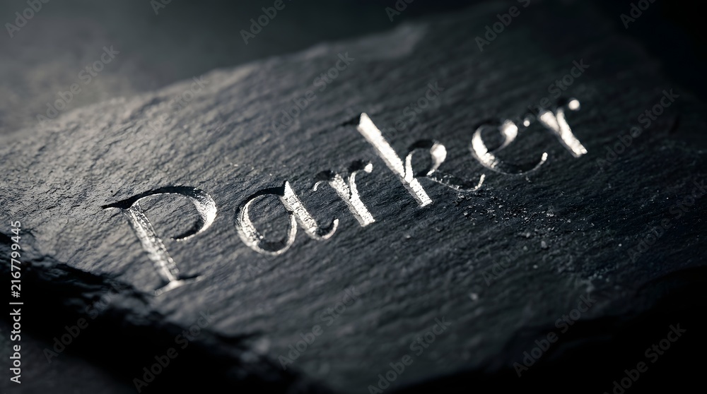 Fototapeta premium Close-up of the engraved name Parker on a dark textured surface.