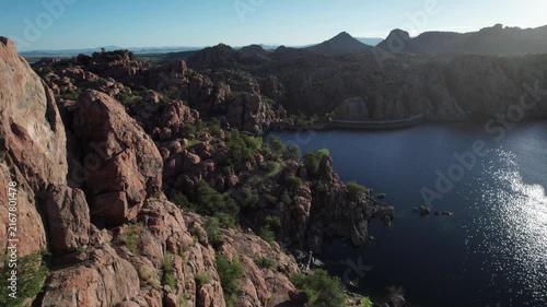 Aerial reveal of granite cliffs along a scenic lake in the American southwest