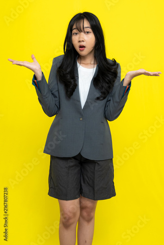 Foto Confused Young Asian Woman In Grey Blazer Gesturing Shrug With Hands Isolated On