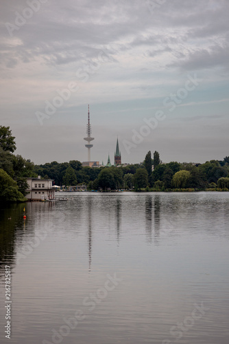 Panoramic view across the Außenalster lake under a soft evening sky in Hamburg, Germany.