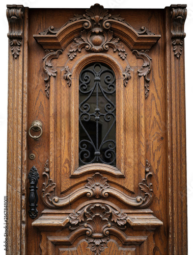 Ornate wooden door features intricate carvings and metal window grate. Traditional craftsmanship details antique entrance, suggesting history and elegant design. Rich wood texture adds warmth.