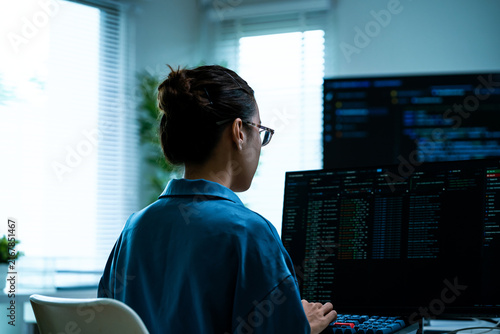 Asian Female Software Engineer Coding on Multiple Monitors at Night Office. Software Development, Big Data Analytics, Women in Tech, Cyber Security, Remote Programming