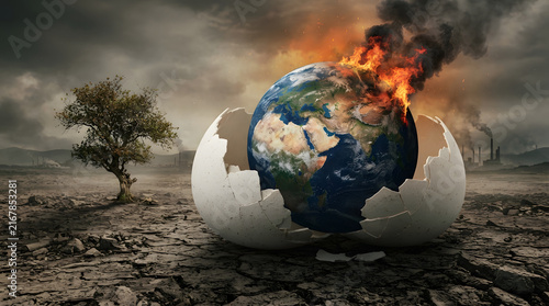 Cracked egg shell holding burning earth globe on dry barren land for climate change and ecology awareness.