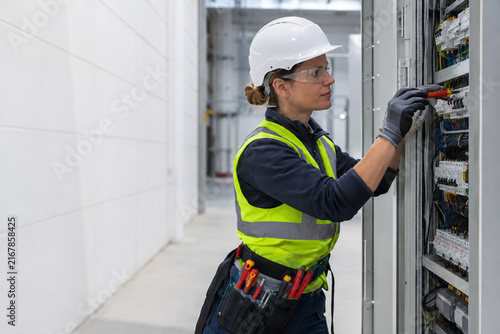 Female Electrician Working on Industrial Electrical Panel