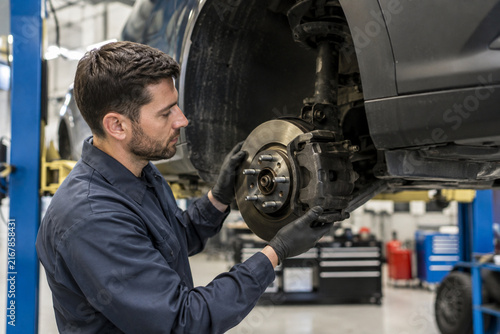 Auto Mechanic Inspecting Vehicle Brake Assembly