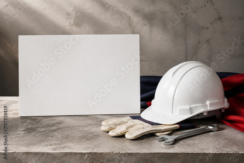 White Hard Hat and Blank Sign on Industrial Workbench